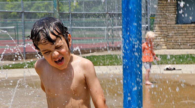 Kayden Jordan, 6, reacts as a bucket full of water spills onto his head Tuesday, June 6, 2024 at the Snyder Park splash pad. BILL LACKEY/STAFF