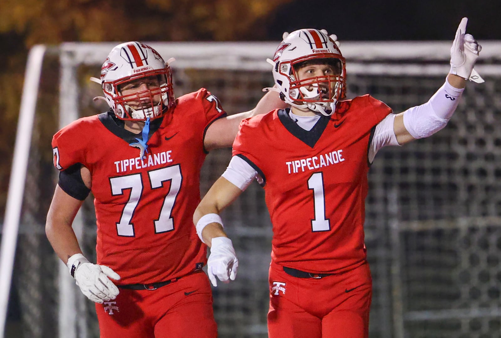 Tippecanoe senior receiver Will Strong motions to fans standing behind the end zone as he's congratulated by Sam Adkins during the first quarter of a Division III, Region 12 quarterfinal on Friday, Nov. 7 at Tipp City Park. Strong scored on a 19-yard TD reception. BRYANT BILLING/STAFF