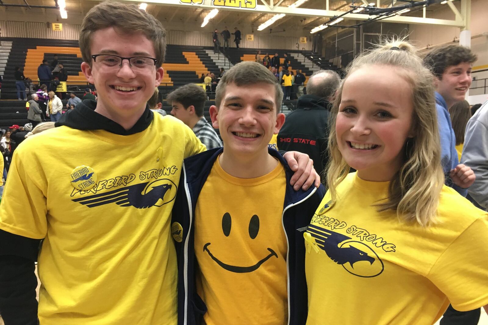 Fairmont junior Paul Kramer (left), senior Benjamin McManus and sophomore Haley Ford celebrate with FIREBIRD STRONG T-shirts and buttons. Fairmont defeated Wayne 51-43 in a boys high school basketball D-I sectional final at Centerville on Monday, March 4, 2019. MARC PENDLETON / STAFF