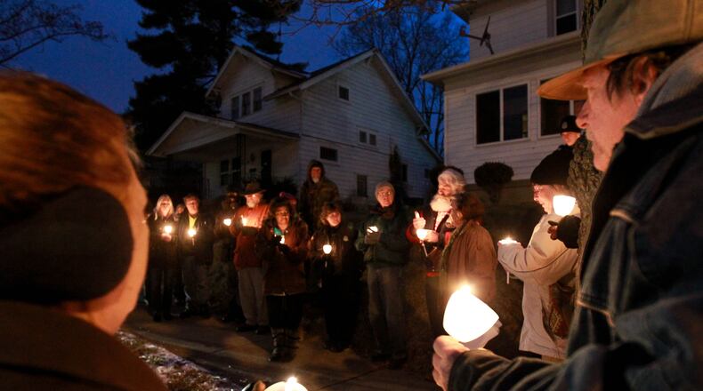 Neighbors and friends are shown at a candlelight vigil for Klonda Richey in February 2015 in front of her former home on Bruce Avenue in Dayton. She was mauled to death by neighbors’ dogs, and a civil lawsuit in the case continues against Montgomery County. FILE