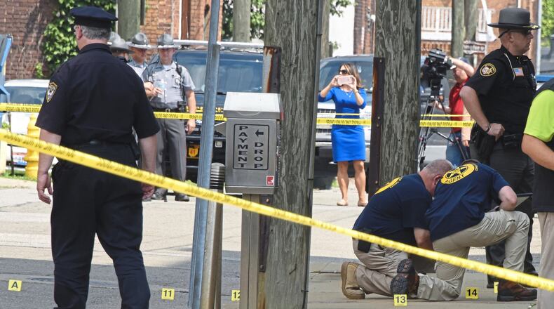 Evidence markers are placed on North Court Street and the sidewalk next to the Jefferson County Courthouse in Steubenville on Monday, Aug. 21, 2017, where a man confronted and shot a local judge. (Darrell Sapp/Pittsburgh Post-Gazette/TNS)