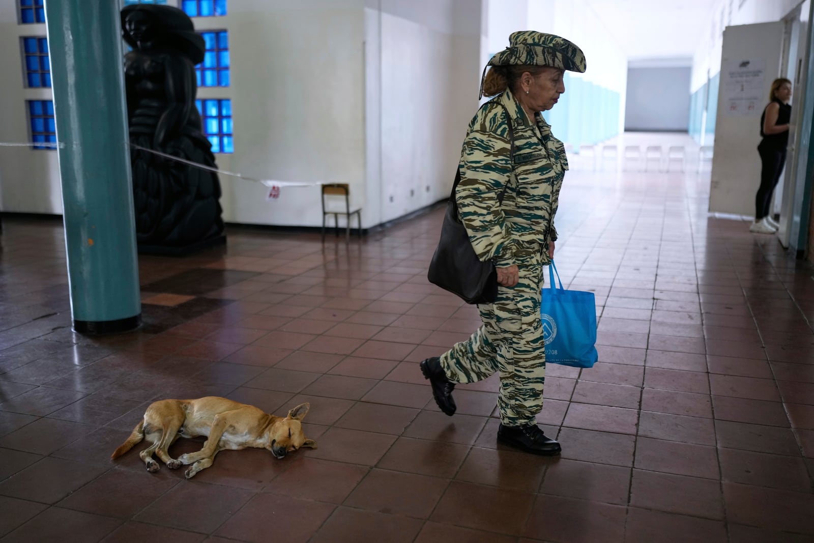 A member of the Bolivarian Militia arrives at a polling station to vote in legislative and local elections in Caracas, Venezuela, Sunday, May 25, 2025. (AP Photo/Ariana Cubillos)