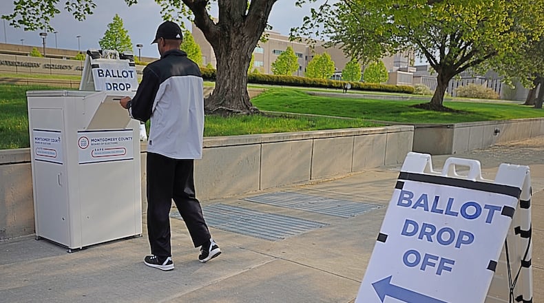 A voter uses the drop box at the Montgomery County Board of Elections on Third Street in Dayton. MARSHALL GORBY / STAFF