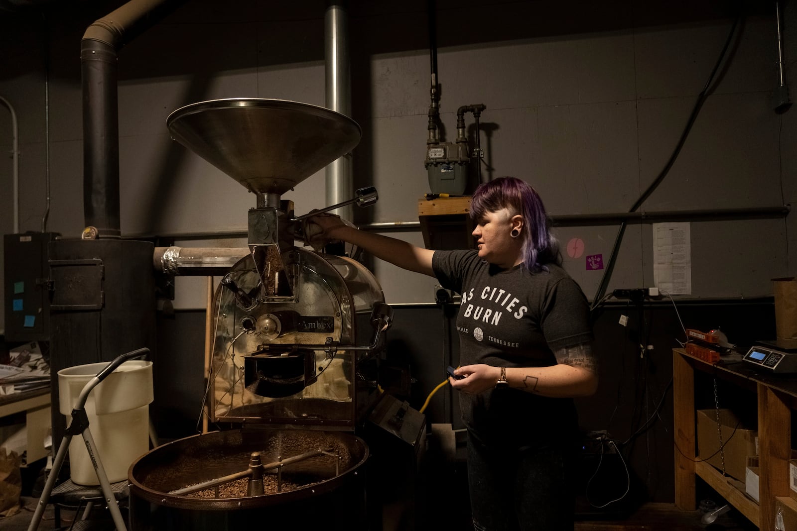 Renee Colon, co-owner of Fuego Coffee Roasters, operates her roasting machine, Friday, March 21, 2025, in Rochester, N.Y. (Max Conway via AP)