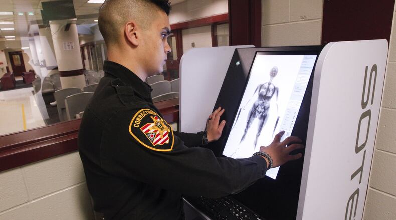 Tyler Viernes, a corrections officer at the Montgomery County Jail, demonstrates a new body scanning system that more than 25,000 inmates a year will pass through. CHRIS STEWART / STAFF