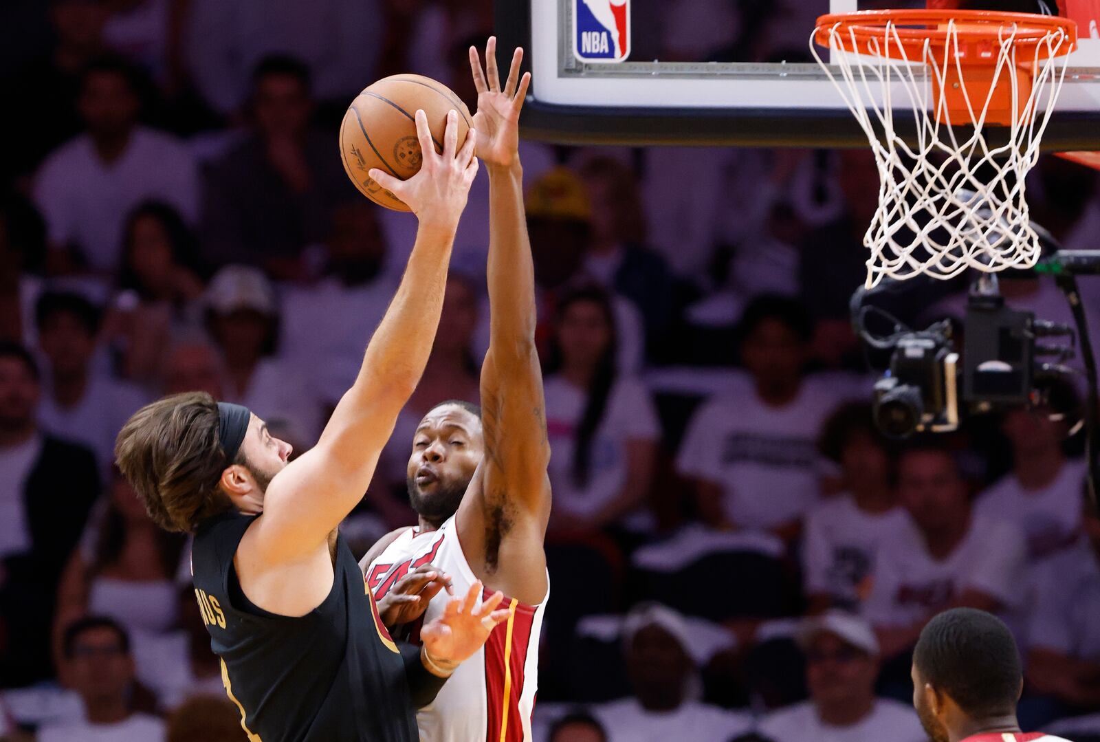 Cleveland Cavaliers guard Max Strus, left, shoots around Miami Heat forward Haywood Highsmith, second from left, during the first half in Game 4 of an NBA basketball first-round playoff series, Monday, April 28, 2025, in Miami. (AP Photo/Rhona Wise)