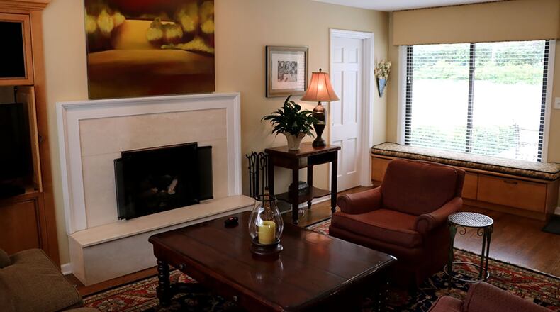 A custom-built entertainment center in the family room is recessed into the wall near the raised fireplace, which is faced in travertine marble. Drawers below the large window seat add storage space.