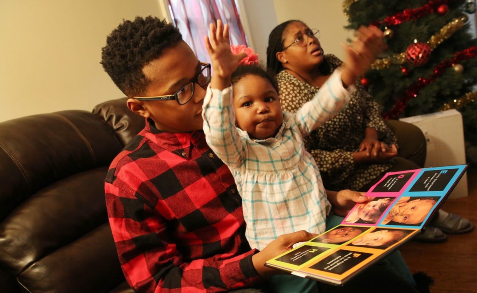 James Huff, 13, reads with his sister, Jenna Huff, 4, in their Cleveland Heights home. The family participates in the Imagination Library, a program started by Dolly Parton that sends free books to preschoolers. GUS CHAN/THE (CLEVELAND) PLAIN DEALER