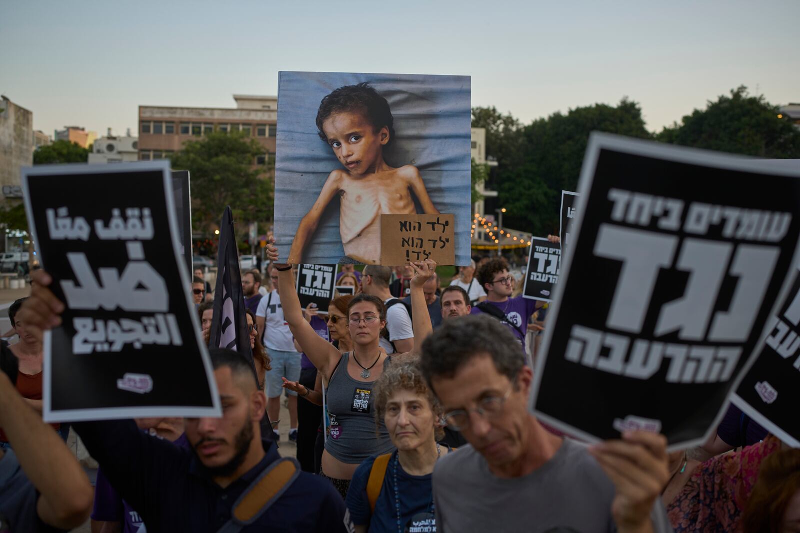 Israeli activists take part in a protest against the war in the Gaza Strip, Israel's measures regarding food distribution and the forced displacement of Palestinians, in Tel Aviv, Israel, Tuesday, July 22, 2025. (AP Photo/Ohad Zwigenberg)