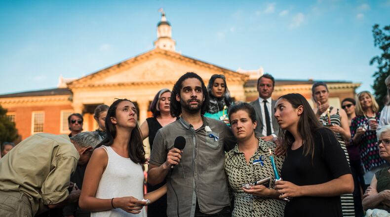 From left: Danielle Ohl, Phil Davis, Rachael Pacella, and Selene San Felice, reporters at the Capital Gazette, address the crowd during a vigil for the victims of the newsroom shooting in Annapolis, Md., June 29, 2018. The crowd held candles and passed around white flowers in the fading light and stifling heat, trying to make sense of a new front in mass shootings: an attack on a local newspaper. (Ryan Christopher Jones/The New York Times)
