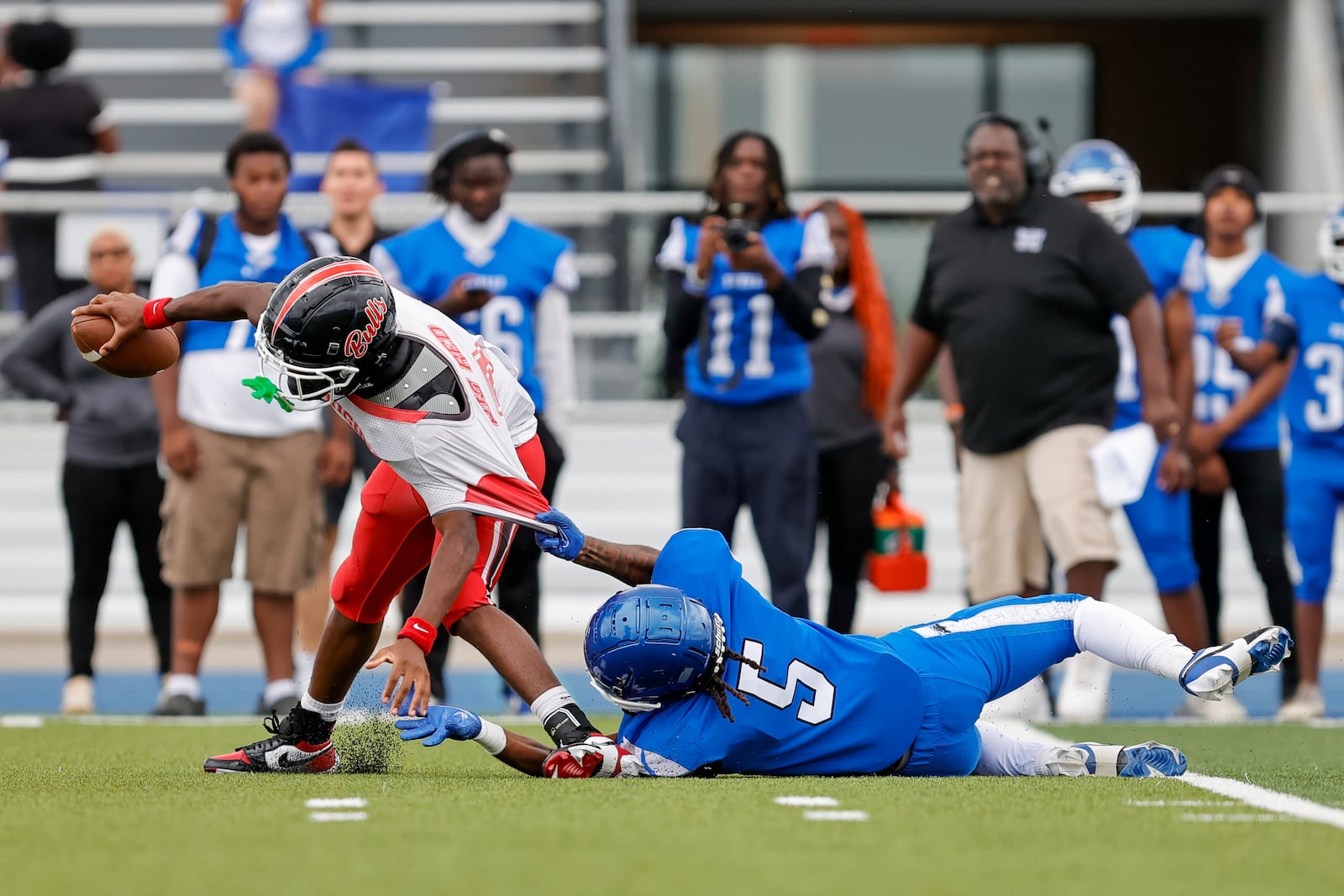 Dunbar High School senior Daiquain Watson brings down Cincinnati Hughes junior Kyell Alexander during their game on Thursday, Aug. 21 at Welcome Stadium. The Big Red won 20-0. MICHAEL COOPER / STAFF