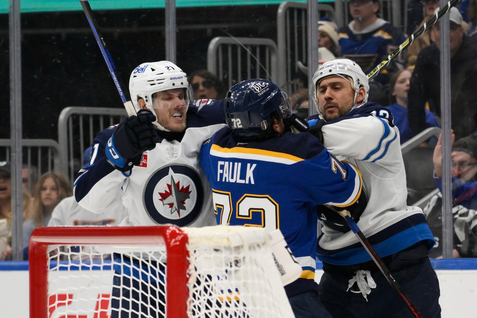 Winnipeg Jets center Dominic Toninato, left, and right wing Nino Niederreiter, right, get physical with St. Louis Blues defenseman Justin Faulk, center, during the third period in Game 6 of an NHL hockey first-round playoff series Friday, May 2, 2025, in St. Louis. (AP Photo/Jeff Le)