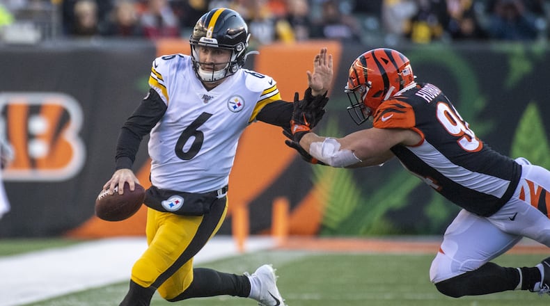 CINCINNATI, OH - NOVEMBER 24: Devlin Hodges #6 of the Pittsburgh Steelers attempts to stiff-arm Sam Hubbard #94 of the Cincinnati Bengals as he runs down the field during the fourth quarter of the game at Paul Brown Stadium on November 24, 2019 in Cincinnati, Ohio. (Photo by Bobby Ellis/Getty Images)