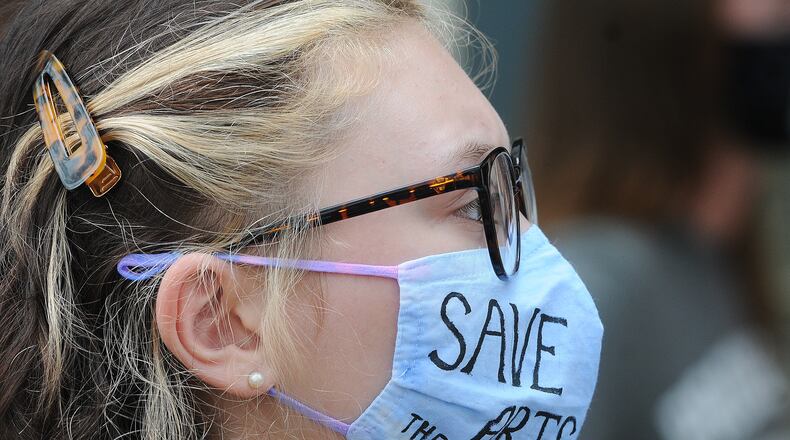 A crowd of people protest layoffs of teachers outside the Dayton Public Schools headquarters building on Ludlow Street Friday.