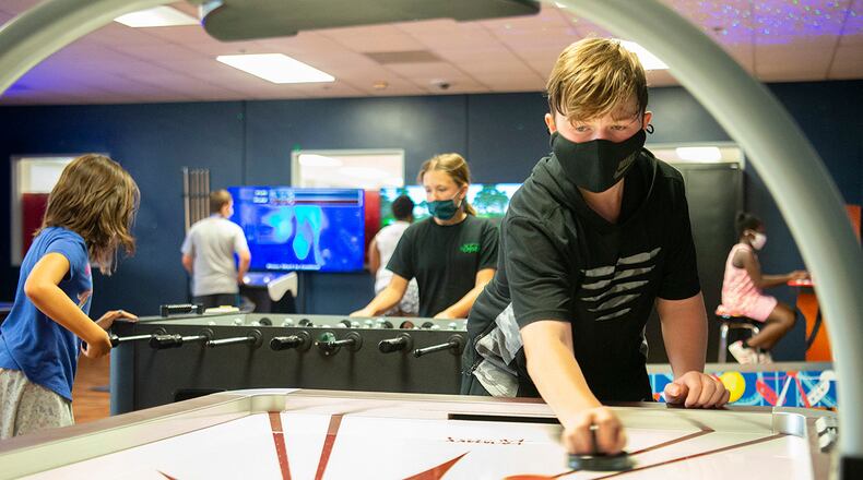 James Smith, 14, plays air hockey as Evelyn Wilbern (center), 12, and Vivian Serna, 9, battle on the foosball table behind him June 10 in the Prairies Youth Center’s new game room. The venue, which is having its grand opening June 18, features free arcade games. The grand opening is only for children in Wright-Patterson Air Force Base’s School-Age Care program. For more information, call 937-656-8688. U.S. AIR FORCE PHOTO/R.J. ORIEZ