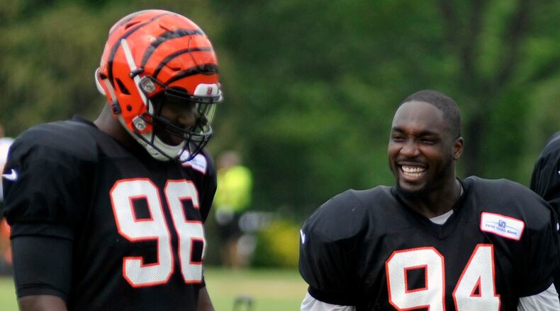 Cincinnati Bengals defensive ends Chris Smith (right) and Carlos Dunlap share a laugh during a break in Thursday’s practice at Paul Brown Stadium. JAY MORRISON/STAFF