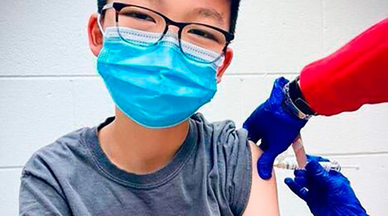 In this Dec. 22, 2020, photo, provided by Richard Chung, his son Caleb Chung receives the first dose of Pfizer coronavirus vaccine or placebo as a trial participant for kids ages 12-15, at Duke University Health System in Durham, N.C. Pfizer says its COVID-19 vaccine is safe and strongly protective in kids as young as 12. The announcement Wednesday, March 31, 2021 marks a step toward possibly beginning shots in this age group before the next school year. (Richard Chung via AP)