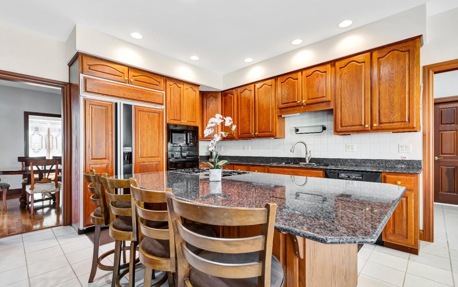 The kitchen has granite countertops and tile backsplash, an island with bar seating and a gas cooktop and updated appliances. CONTRIBUTED