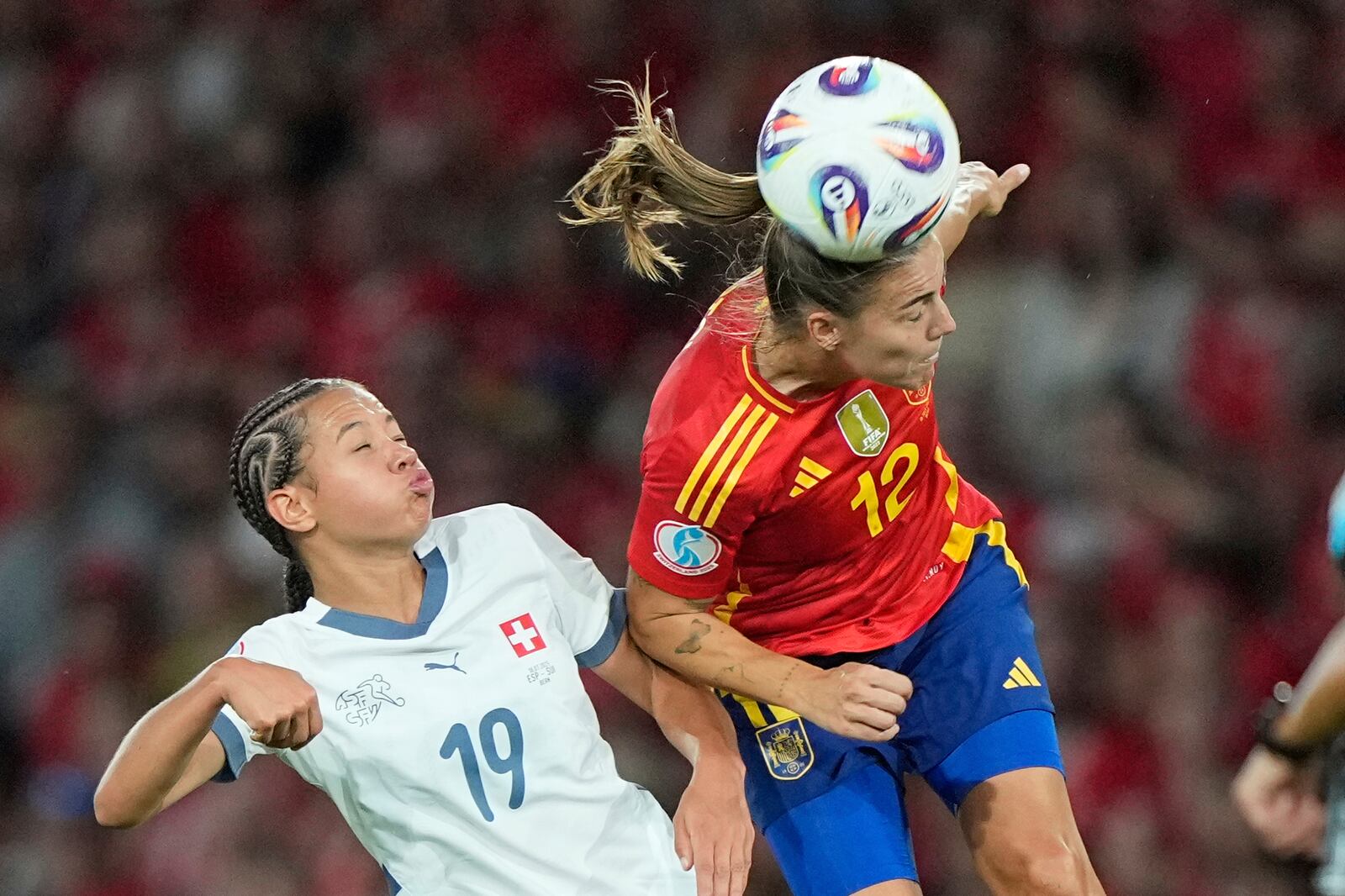 Spain's Patri Guijarro heads the ball ahead of Switzerland's Iman Beney during the Women's Euro 2025 quarterfinals soccer match between Spain and Switzerland at Stadion Wankdorf in Bern, Switzerland, Friday, July 18, 2025. (AP Photo/Martin Meissner)