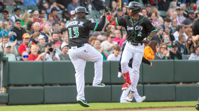 Dayton's Carlos Jorge is greeted by manager Vince Harrison Jr. as he rounds third after leading off the second inning with his fourth home run. Jeff Gilbert/CONTRIBUTED