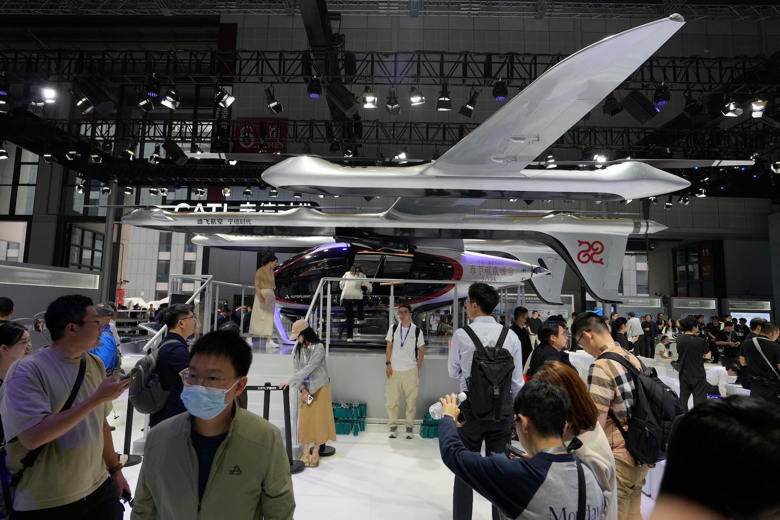 Visitors stand near a flying test platform from Chinese battery manufacturer CATL during the Shanghai auto show on Wednesday, April 23, 2025. (AP Photo/Ng Han Guan)