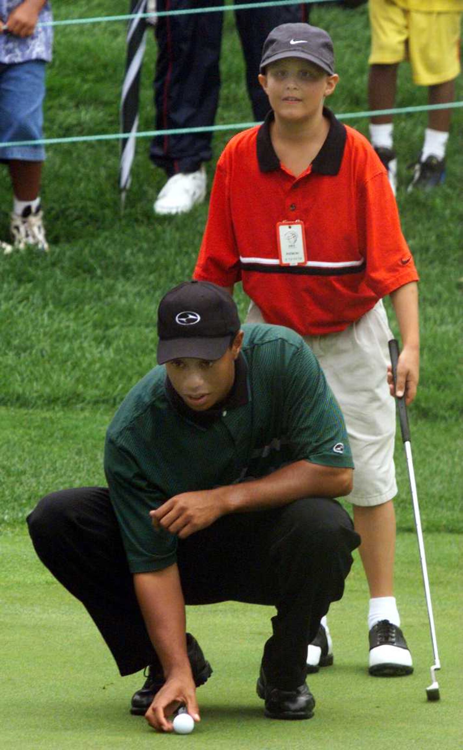 AKRON, OHIO, AUGUST 25 ----- Helping Tiger Woods line up his putt on his round today in Dan Herchline (11) of Beavercreek. It was Dan's special wish to walk a round with his favorite golfer, the Tiger, at the Firestone Country Club that is hosting the NEC Invitational.