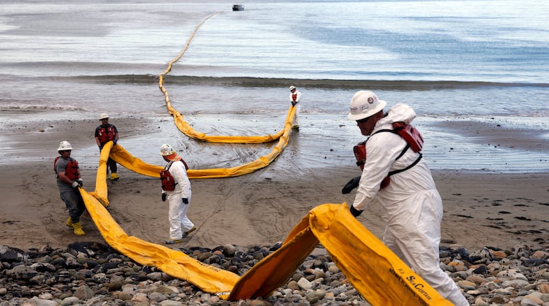 FILE - Workers prepare an oil containment boom at Refugio State Beach, north of Goleta, Calif., on May 21, 2015, two days after an oil pipeline ruptured, polluting beaches and killing hundreds of birds and marine mammals. (AP Photo/Jae C. Hong, File)