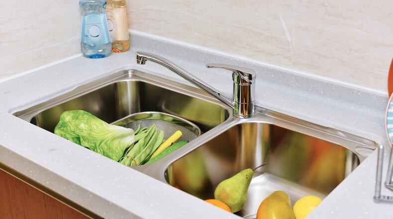 The constant mix of moisture and food in the kitchen sink makes it prone to bacteria like E. coli and salmonella. (Dreamstime)