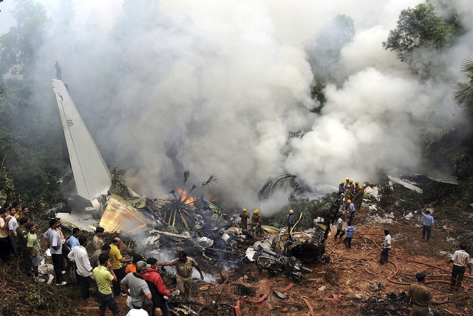 FILE - Civilians look on as Indian firefighters and rescue personnel work on the site of an Air India plane that crashed in Mangalore, in the southern Indian state of Karnataka, Saturday, May 22, 2010. (AP Photo, File)