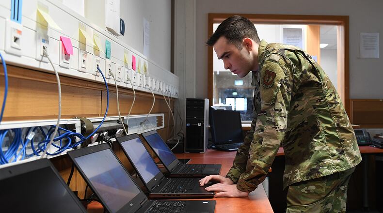 Airman 1st Class Wesley Carrow, 52nd Communications Squadron client systems technician, performs routine maintenance on computer systems connected to the Air Force network April 6. In June, the Enterprise IT-as-a-Service Integrated Program Office, headquartered at Hanscom Air Force Base, Mass., began migrating users at a number of military installations to commercially available networks provided by both AT&T and Microsoft. (U.S. Air Force photo/Airman 1st Class Alison Stewart)