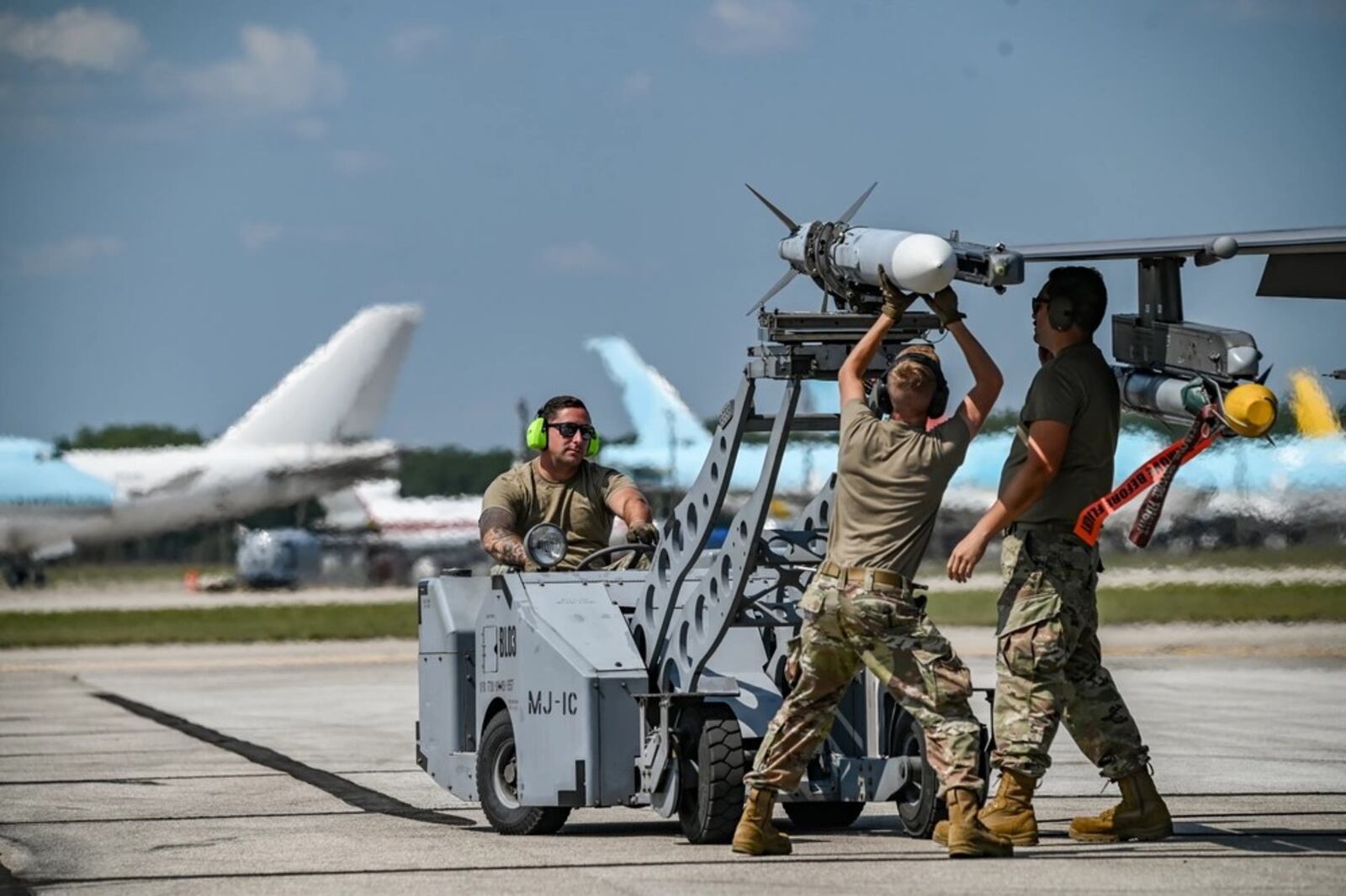 From left to right, Air Force Tech. Sgt. Anthony Barrow, 180th Maintenance Squadron (MXS) munitions systems specialist, 180th Fighter Wing, Ohio Air National Guard, Lucas County, Ohio, Airman 1st Class Andrew Stephens, 180th MXS weapons loader and Tech. Sgt. Evan Sanders, 180th MXS weapons loader, prepare an F-16C Fighting Falcon for takeoff during Exercise Northern Strike 24-2 at Oscoda-Wurtsmith Airport, Iosco County, Michigan, Aug. 14, 2024. Air National Guard photo