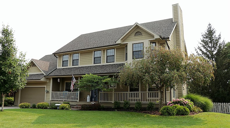The Hardieplank-sided home has about 3,880 sq. ft. of living space, including the finished walk-out lower level. Double overhead garage door opens into a tandem 3-car garage. A covered porch stretches across the front of the house. CONTRIBUTED PHOTO BY KATHY TYLER