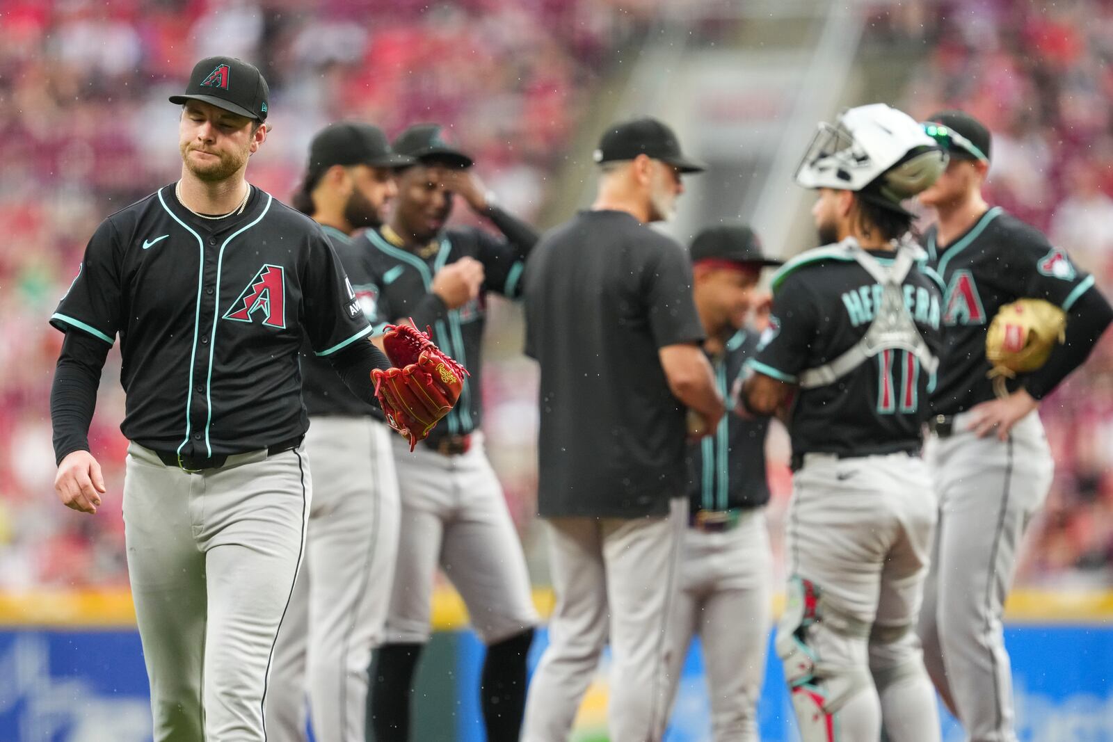 Arizona Diamondbacks' Ryne Nelson, left, reacts as he walks to the dugout following a pitching change in the fourth inning of a baseball game against the Cincinnati Reds, Saturday, June 7, 2025, in Cincinnati. (AP Photo/Jeff Dean)