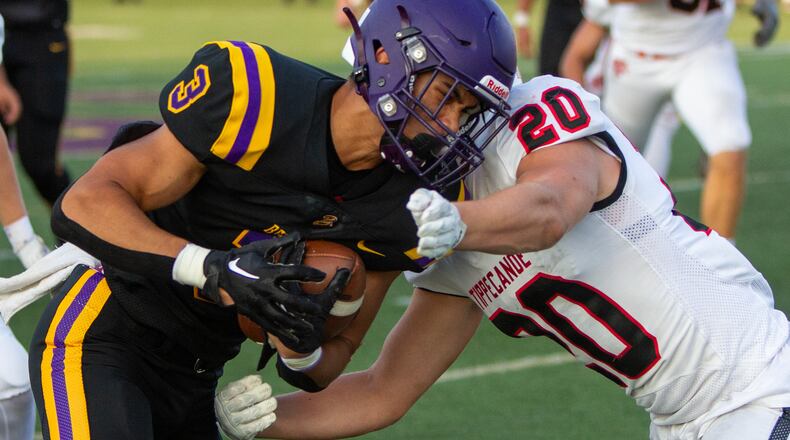 Bellbrook's Jake Lopez pushes for yardage against Tippecanoe's Andrew Oen during Friday night's game at Bellbrook. The Golden Eagles won 21-7. Jeff Gilbert/CONTRIBUTED