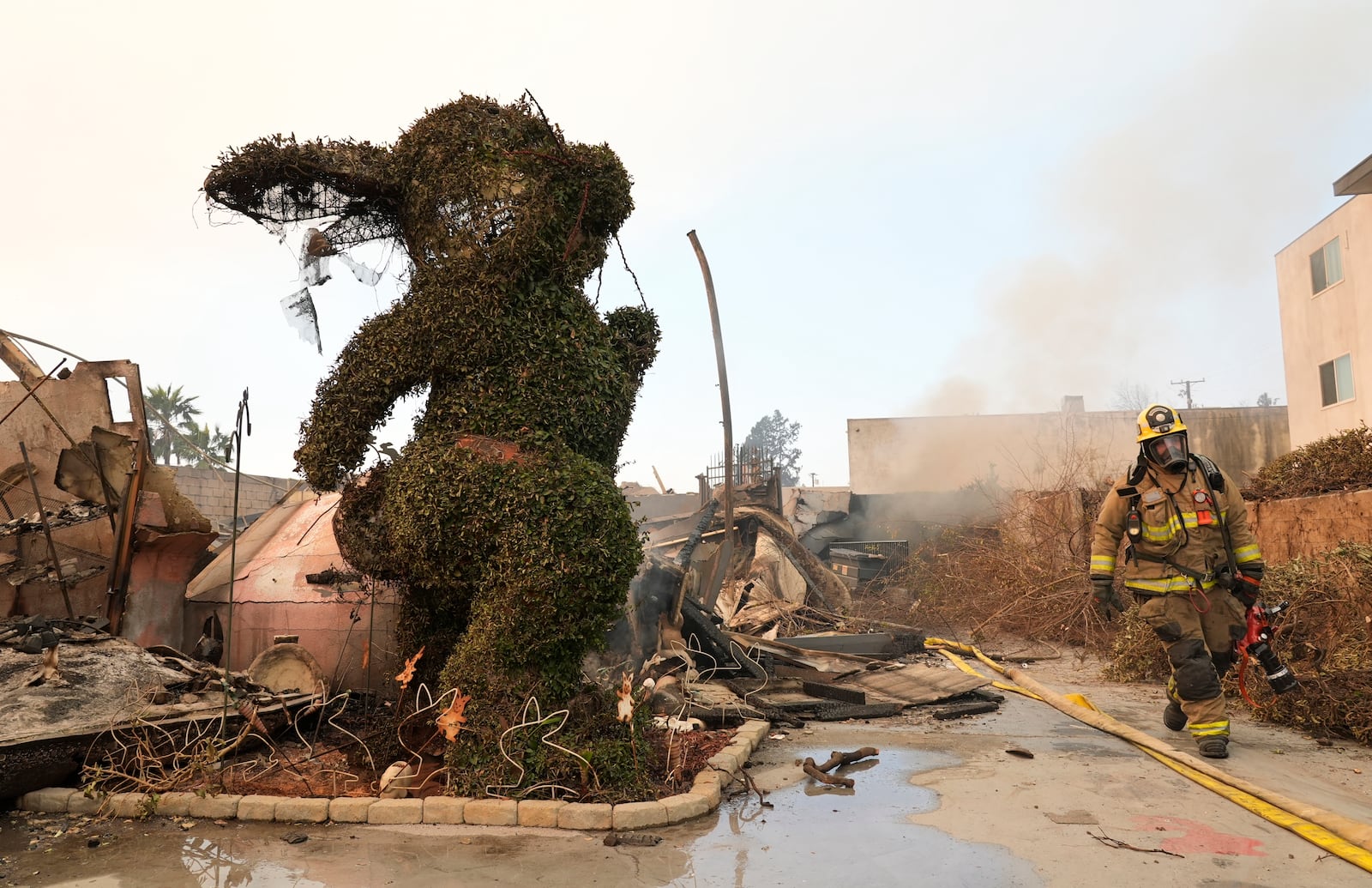 FILE - A firefighter walks past a charred bunny sculpture and debris from The Bunny Museum, Jan. 9, 2025, in Altadena, Calif. (AP Photo/Chris Pizzello, File)