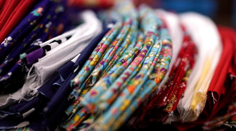 FILE PHOTO: In this Monday, Feb. 17, 2020 photo, the handmade cotton masks are made by volunteers. Should children wear masks to protect against spreading coronavirus? The CDC says it depends on their ages.