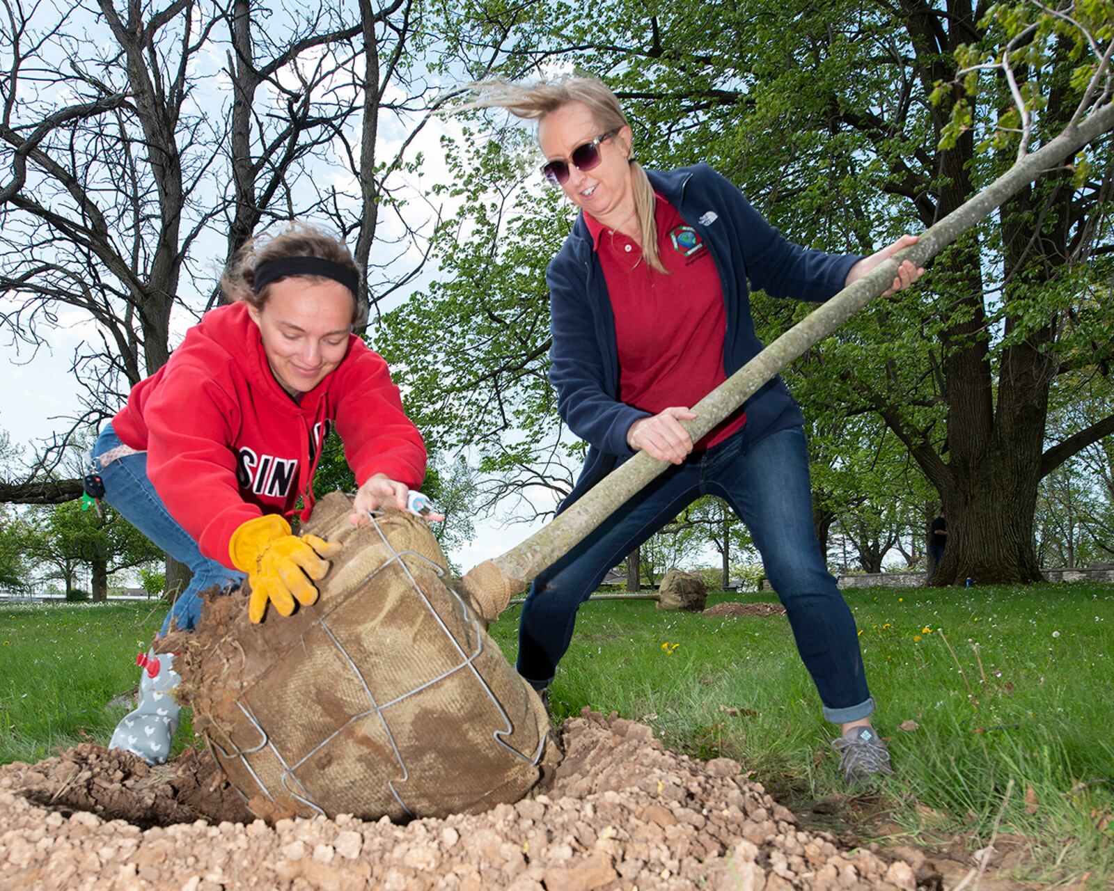 Layla Hatfield (left) and Danielle Trevino, both with the 88th Civil Engineer Group’s Environmental Branch, place a Wright Brothers Sugar Maple in a pre-dug hole at the Wright Brothers Memorial on April 30 as part of Wright-Patterson Air Force Base’s Arbor Day observance. This variety of maple was developed by a local nursery and named after the aviation pioneers. U.S. AIR FORCE PHOTO/R.J. ORIEZ