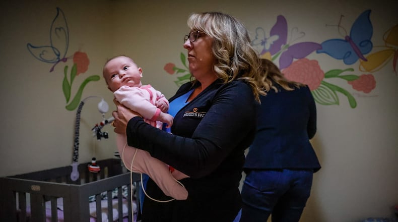 Jill Kingston holds an infant at Brigid's Path in Kettering. Kingston is the founder and president of the facility, which has helped approximately 250 newborns for nearly six years. JIM NOELKER/STAFF