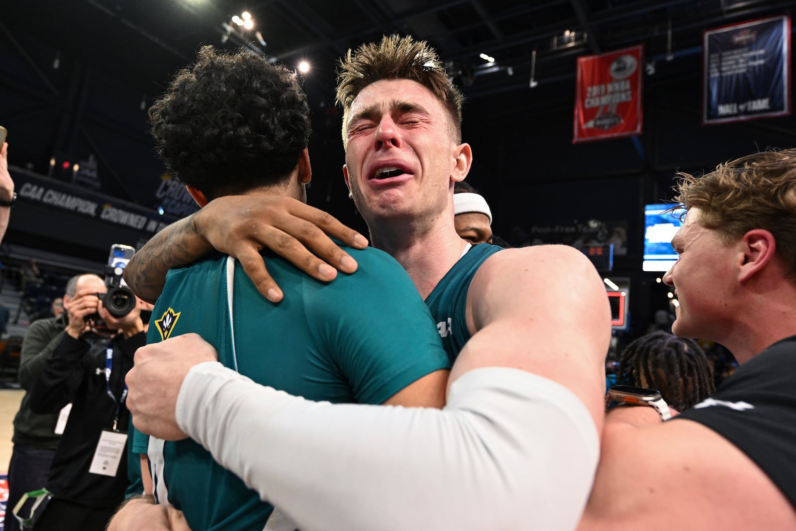 UNC Wilmington guard Noah Ross, right, hugs guard Nolan Hodge after the team defeated Delaware in an NCAA college basketball game in the championship of the Coastal Athletic Association tournament, Tuesday, March 11, 2025, in Washington. (AP Photo/Terrance Williams)