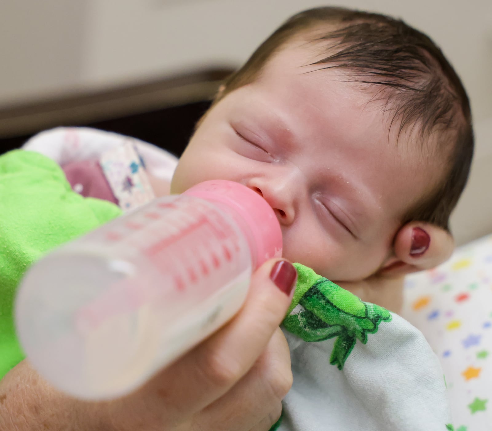 An infant feeds on a bottle held a nurse at Brigid's Path on Wednesday, Feb. 18 in Kettering. The newborn recovery center, which has helped more than 300 babies since 2014, will soon be the first of its type in the country to receive Medicaid reimbursement for instants treated for neonatal abstinence syndrome. BRYANT BILLING / STAFF