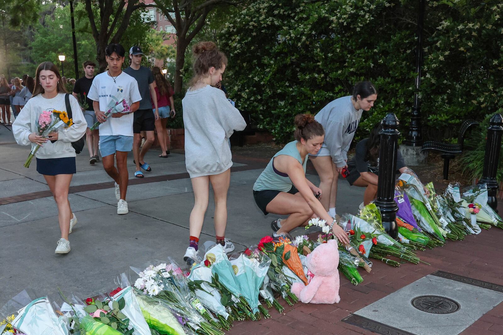 An impromptu memorial shared online brings students bearing flowers near the center of the Florida State campus in sight of the Student Union building, Tallahassee, Fla., Thursday, April 17, 2025. (AP Photo/Gary McCullough)