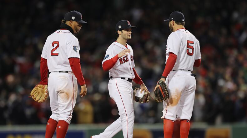 BOSTON, MA - OCTOBER 24:  Xander Bogaerts #2, Andrew Benintendi #16 and Ian Kinsler #5 of the Boston Red Sox celebrate their teams 4-2 win over the Los Angeles Dodgers in Game Two of the 2018 World Series at Fenway Park on October 24, 2018 in Boston, Massachusetts.  (Photo by Elsa/Getty Images)
