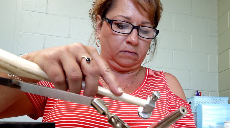Amy Hamilton, owner of One Four 925, works on a ring in the work area of her New Carlisle store Monday. Bill Lackey/Staff