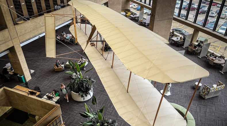 A replica of the Wright Flyer hangs over the students at Wright State University library. JIM NOELKER/STAFF