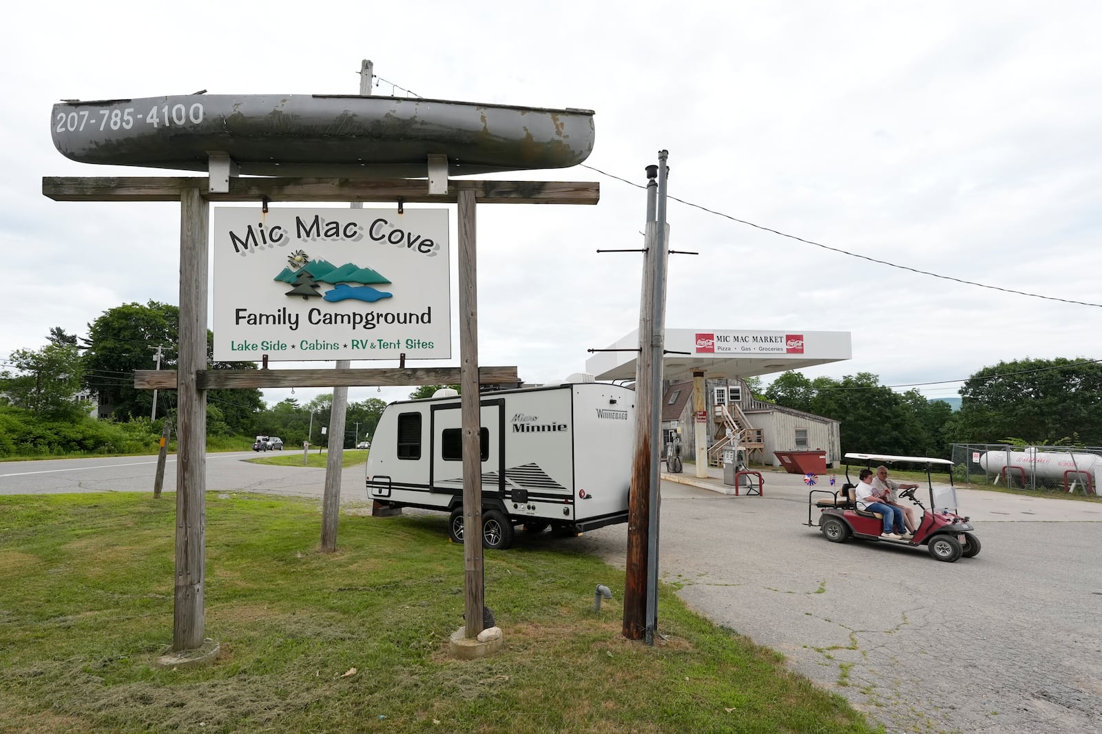 Campers ride a golf cart to the Mic Mac Cove Campground, Wednesday, July 9, 2025, in Union, Maine, where police have used the campground to access Crawford Pond to investigate the murder of a woman last seen paddleboarding on the pond. (AP Photo/Robert F. Bukaty)