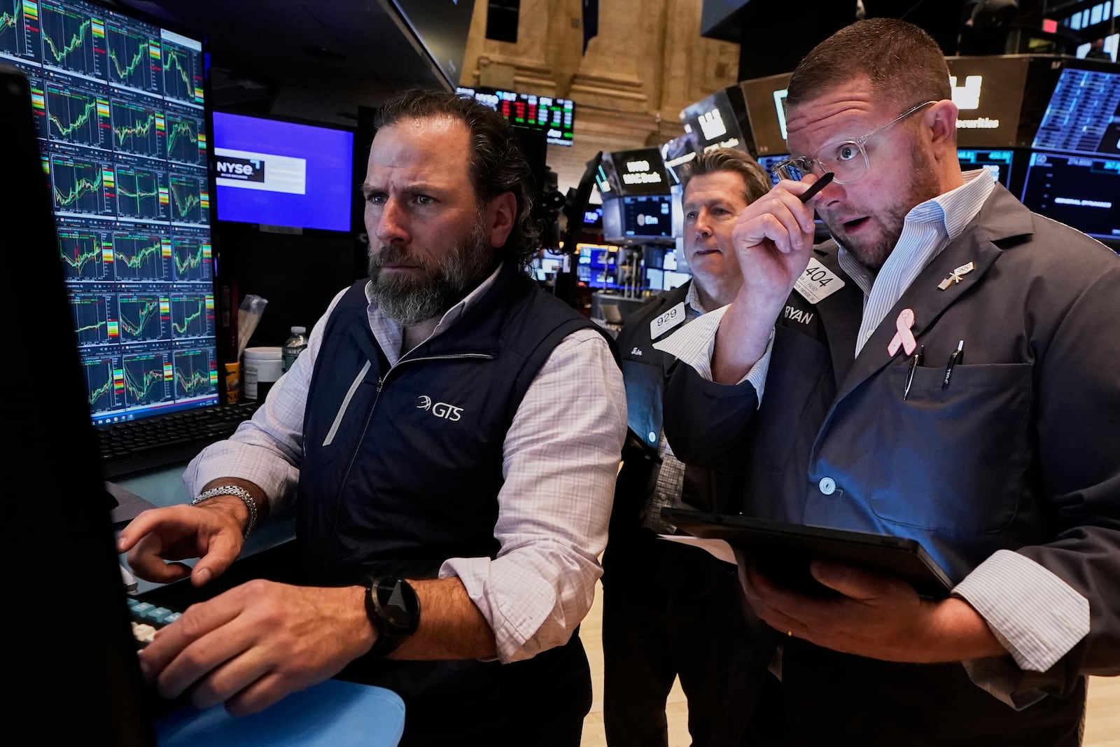 Specialist Michel Pistillo, left, works with traders James Matthews, center, and Ryan Falvey on the floor of the New York Stock Exchange, Wednesday, April 23, 2025. (AP Photo/Richard Drew)