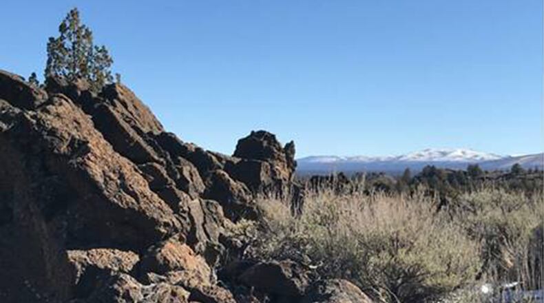Snow-covered hills can be seen in the distance from Flatiron Rock in the Badlands. (Mark Morical/The Bulletin/TNS)