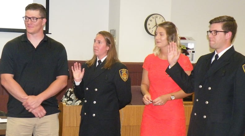Sarah Wagner and Jeremy Smith were given their oaths as the city s first full-time firefighter/paramedics in the history of the Oxford Fire Department on June 20. At left is Wagner s boyfriend Jason Hudnall, who pinned on her badge while Smith s wife, Molly, pinned on his. CONTRIBUTED