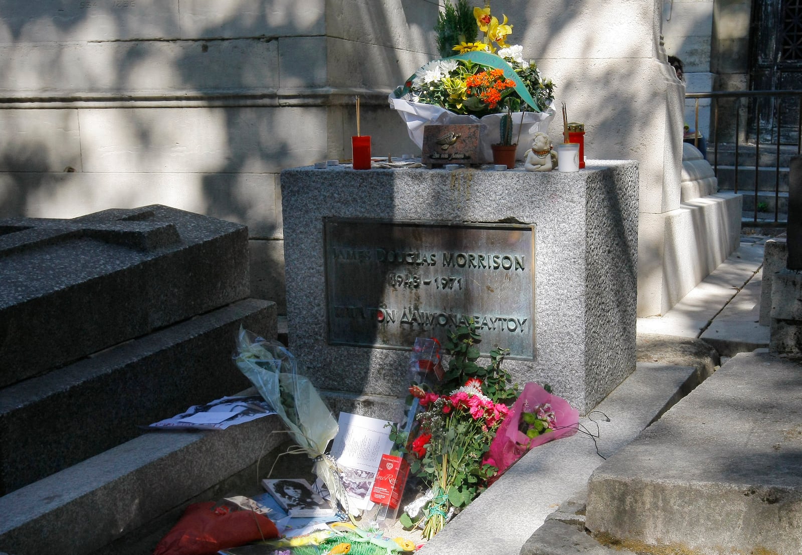 FILE - Flowers and candles adorn the grave of legendary rock front man and poet with the Doors rock band, Jim Morrison at the Pere Lachaise cemetery in Paris Monday July. 3, 2011. Morrison, the legendary singer of the rock band died in Paris on July, 2, 1971. (AP Photo/Jacques Brinon, File)