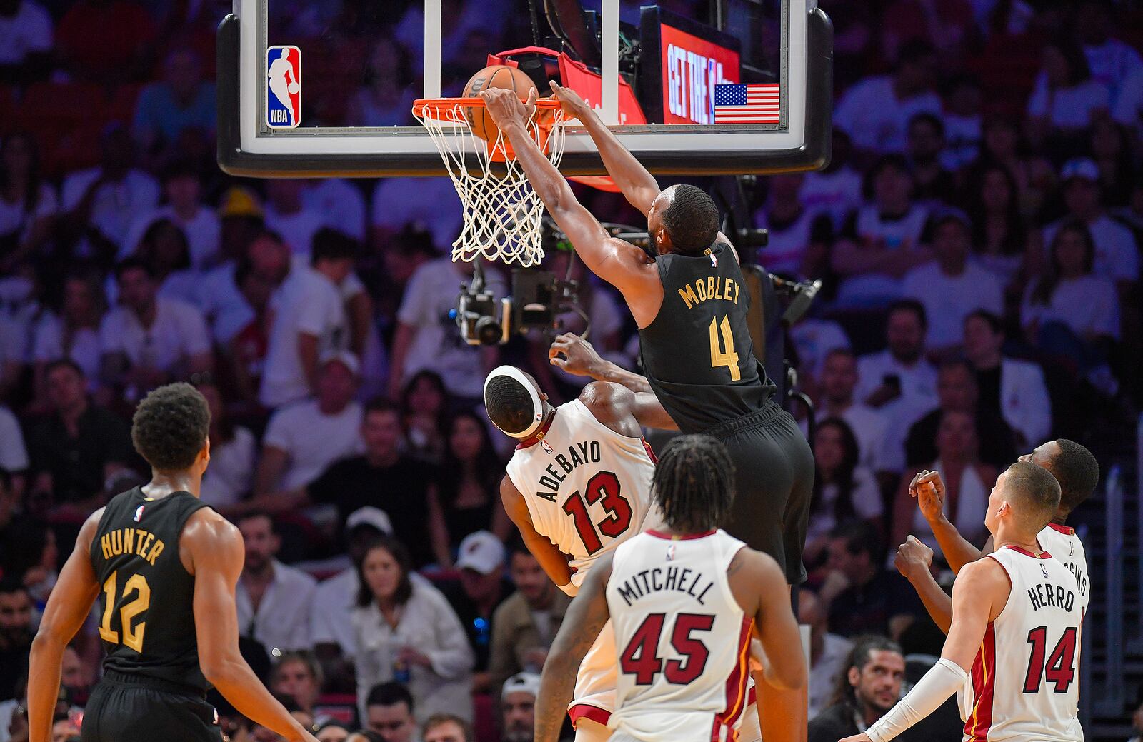 Cleveland Cavaliers forward Evan Mobley (4) dunks over Miami Heat center Bam Adebayo (13) during the first half in Game 3 of an NBA basketball first-round playoff series, Saturday, April 26, 2025, in Miami. (AP Photo/Michael Laughlin)